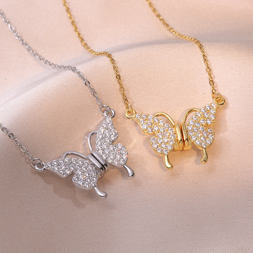 Butterfly-shaped necklaces in gold and silver on a beige background