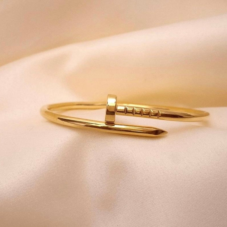 Gold bangle on a beige fabric background