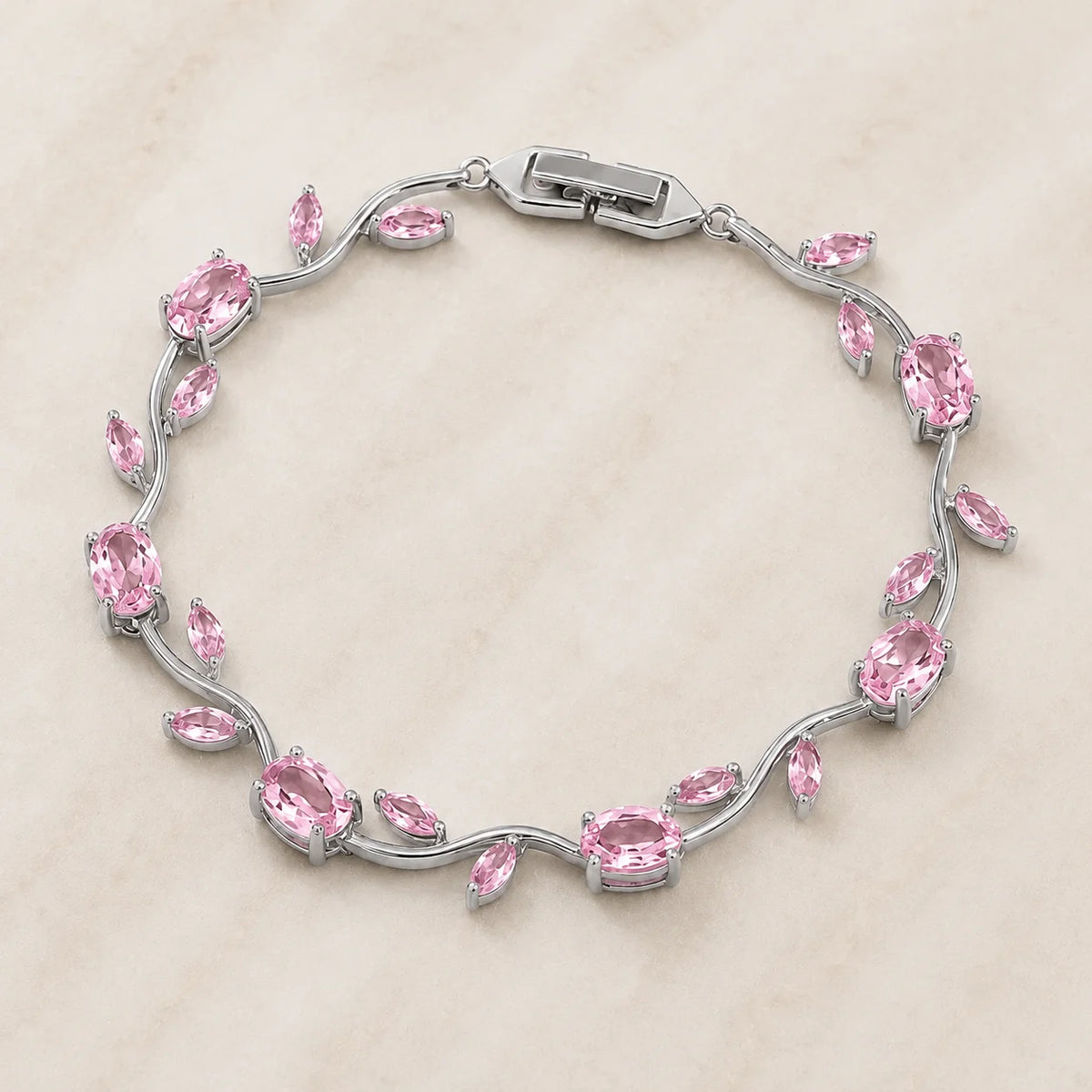 Silver bracelet with pink gemstones on a beige background
