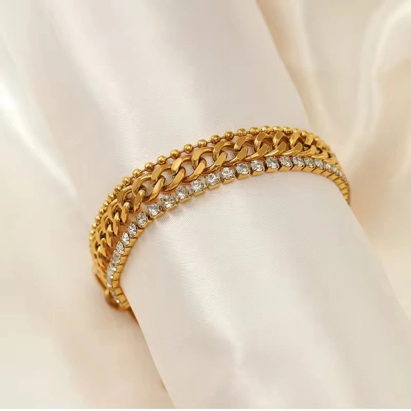 Gold bracelet with embedded diamonds on a white fabric background