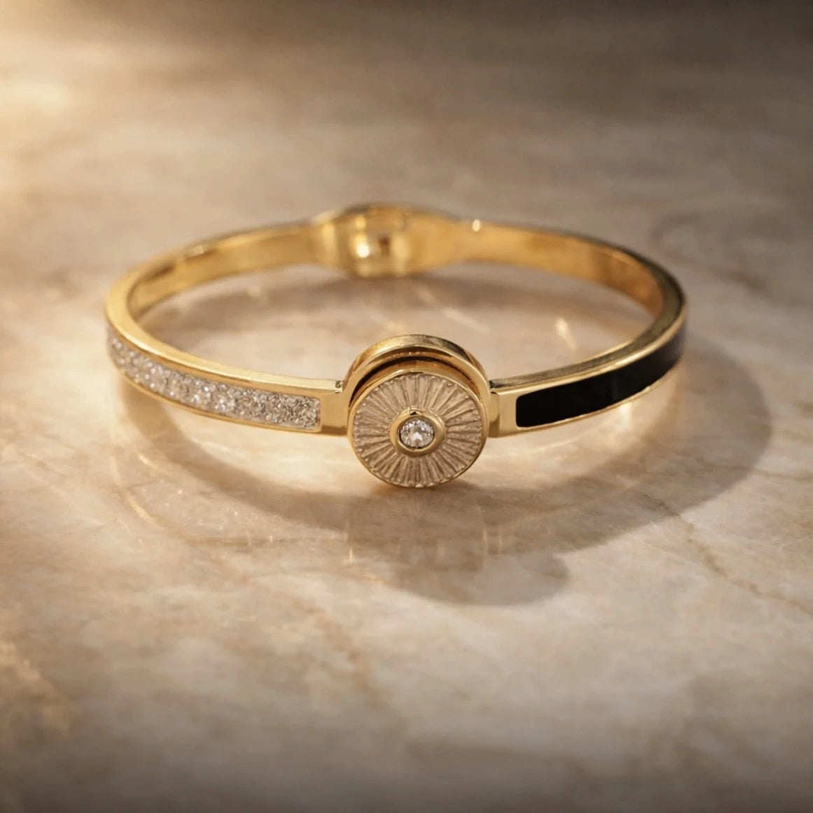 Gold bracelet with a central diamond on a beige marble background