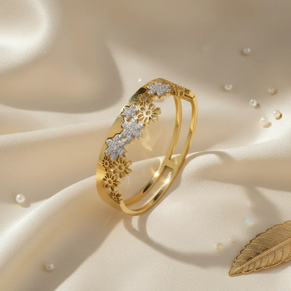 Gold bracelet with floral designs on a beige fabric background