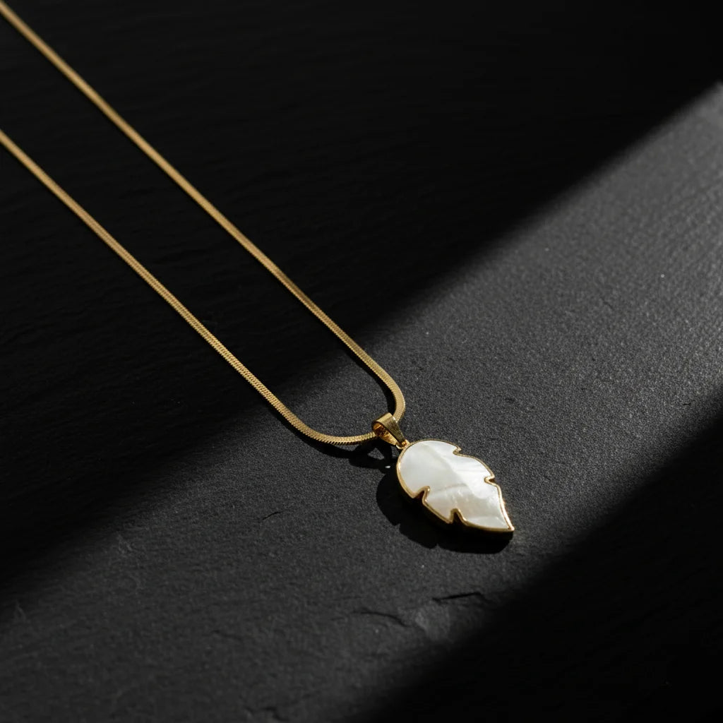 Necklace with a leaf-shaped pendant on a dark surface
