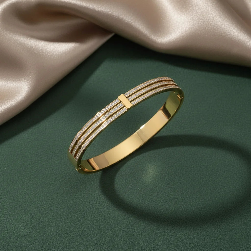 Gold bracelet on a green surface with a beige fabric background