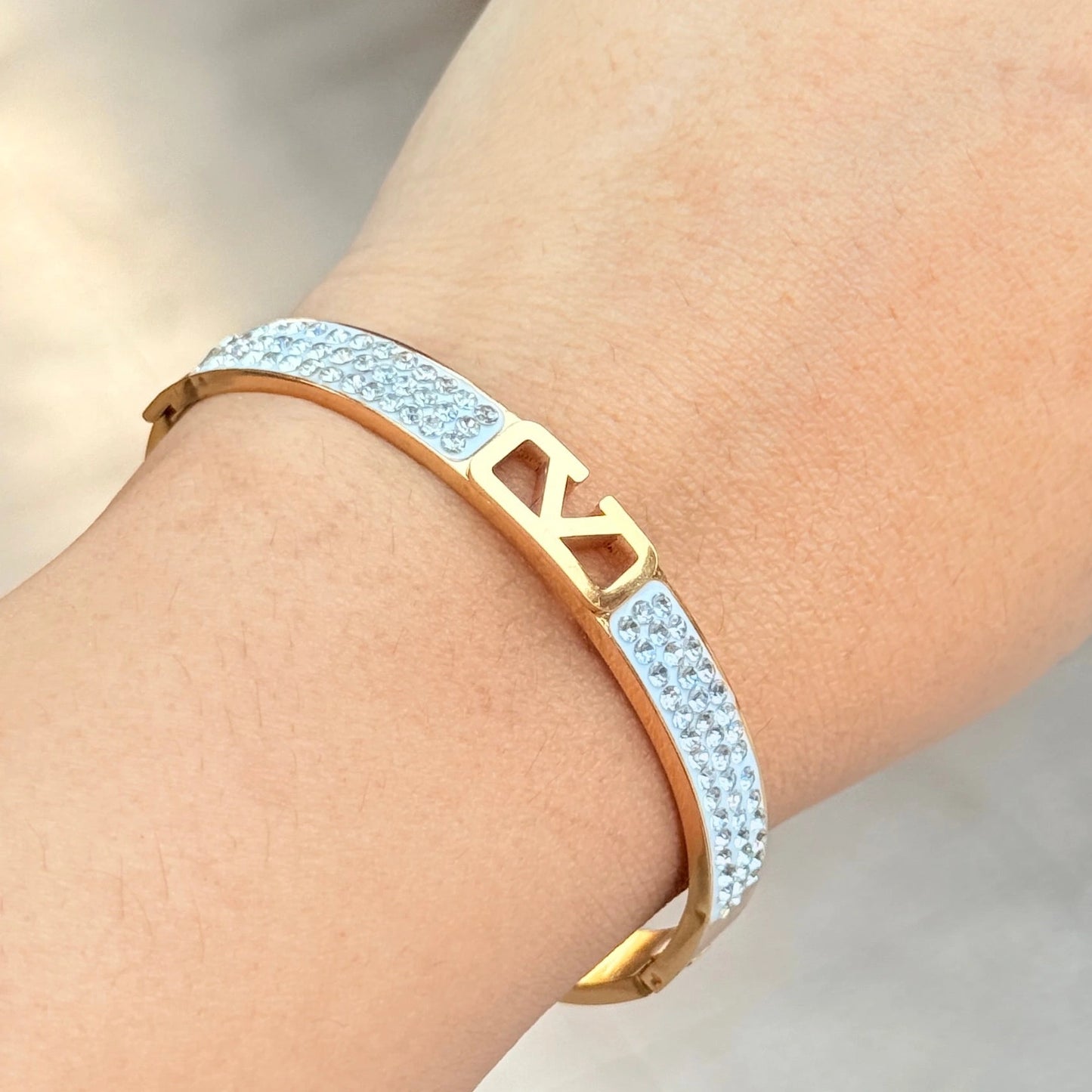 Gold and silver bracelet on a wrist with a blurred background
