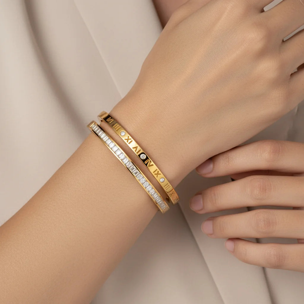 Gold bracelet with diamond accents on a wrist against a neutral background
