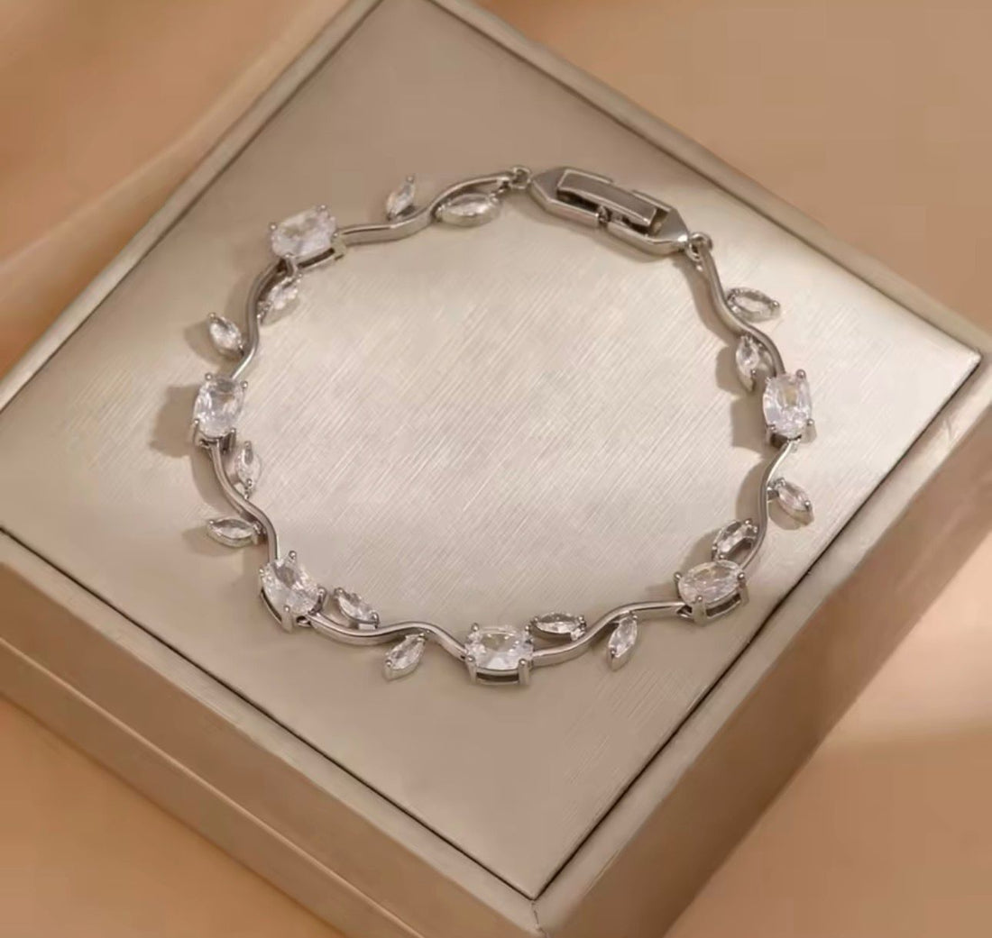 Silver bracelet with clear stones on a beige box