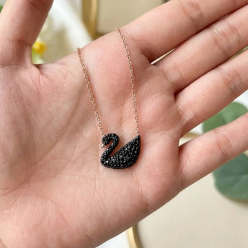 Swan pendant in black handson
