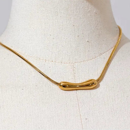 Gold necklace on a mannequin bust against a white background