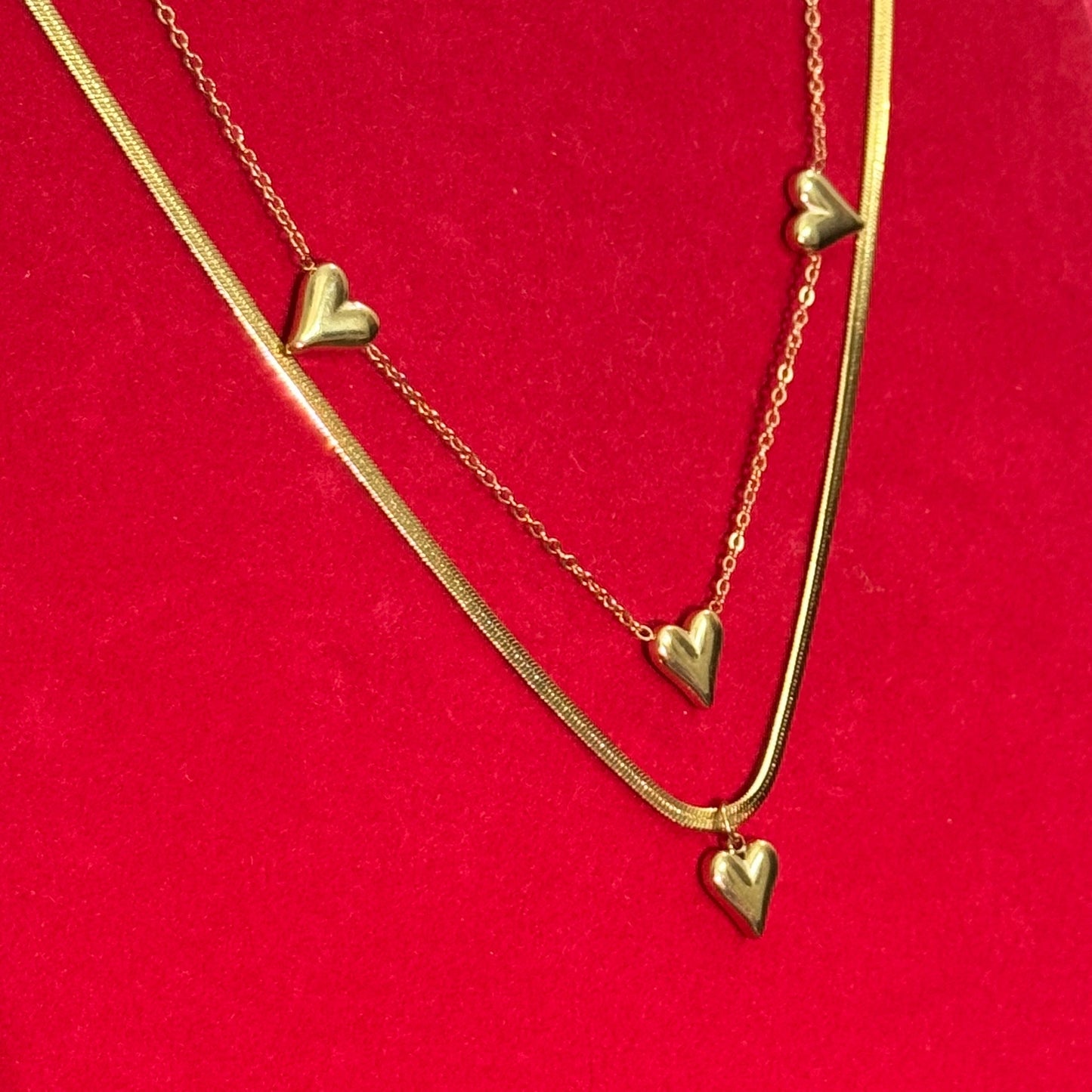 Gold heart-shaped necklace on a red background