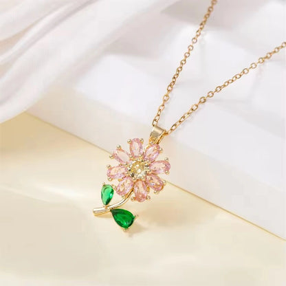 Necklace with a pink floral pendant and green gemstones on a white background
