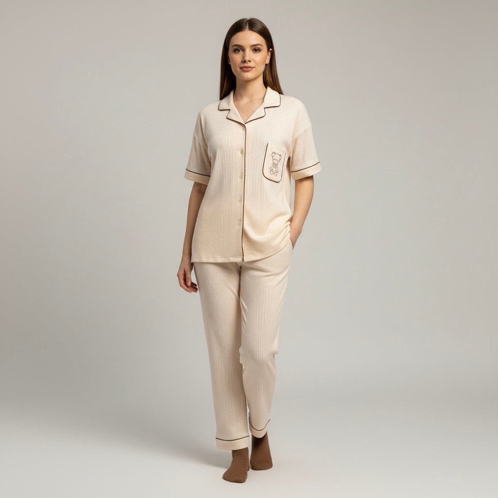 Woman wearing a beige pajama set against a gray background