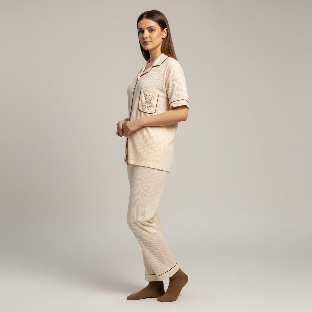 Woman wearing a beige pajama set with a plain background