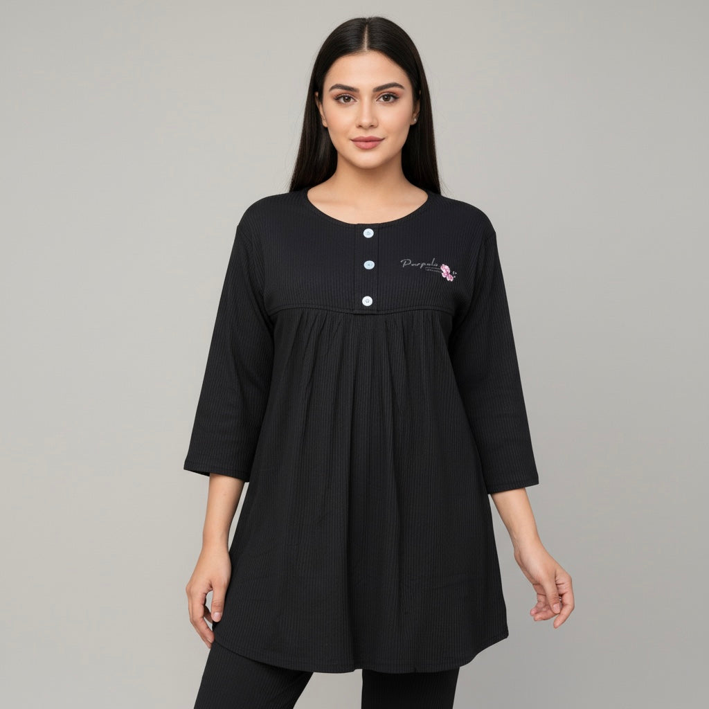 Woman wearing a black dress with embroidery on a gray background