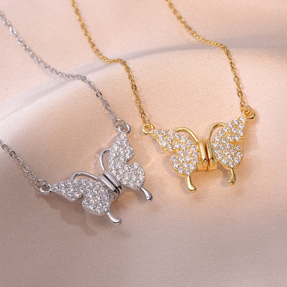 Butterfly-shaped necklaces in gold and silver on a beige background