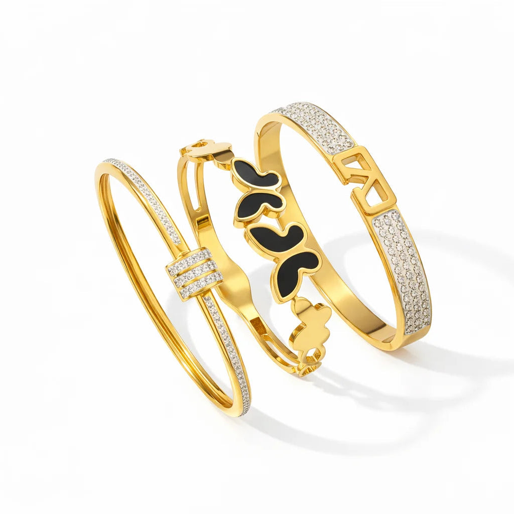 Three gold bracelets with different designs on a white background