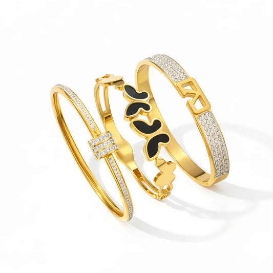 Three gold bracelets with different designs on a white background