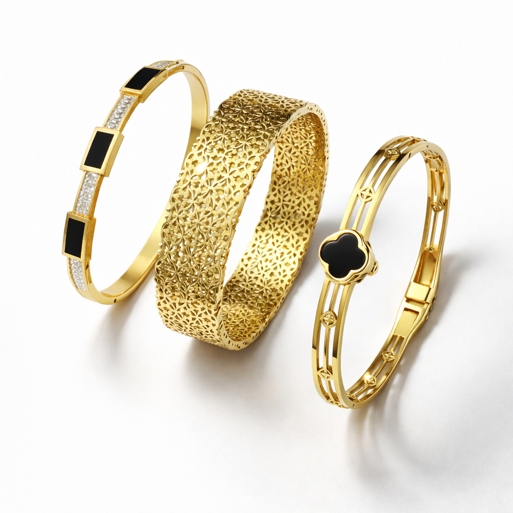 Three gold bracelets with black accents on a white background