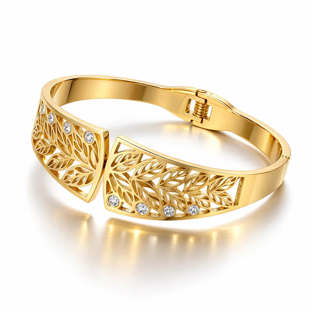 Gold bracelet with leaf designs and clear stones on a white background