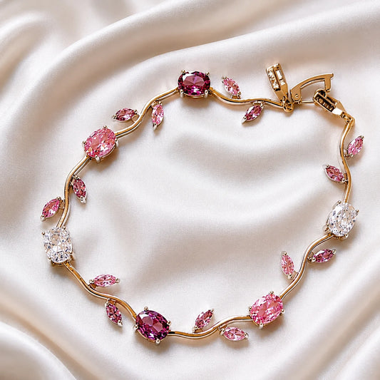 Gold bracelet with pink gemstones on a white fabric background