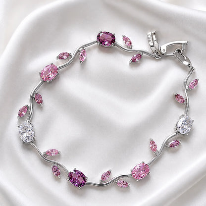 Silver bracelet with pink and clear gemstones on a white background