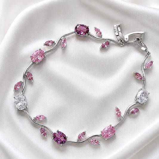 Silver bracelet with pink and clear gemstones on a white background