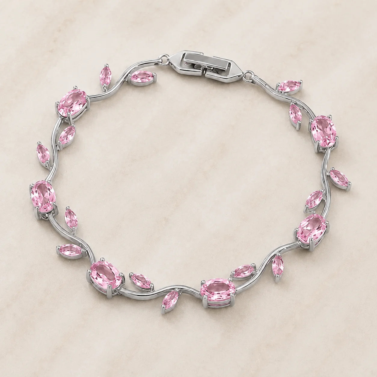 Silver bracelet with pink gemstones on a beige background