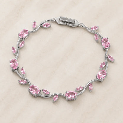 Silver bracelet with pink gemstones on a beige background