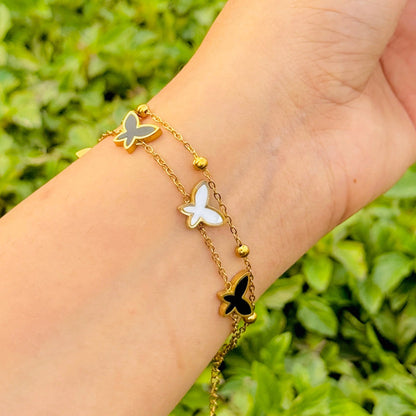 Butterfly bracelet on a wrist with a green leafy background