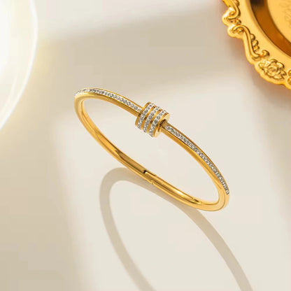 Gold bracelet with diamond accents on a light background