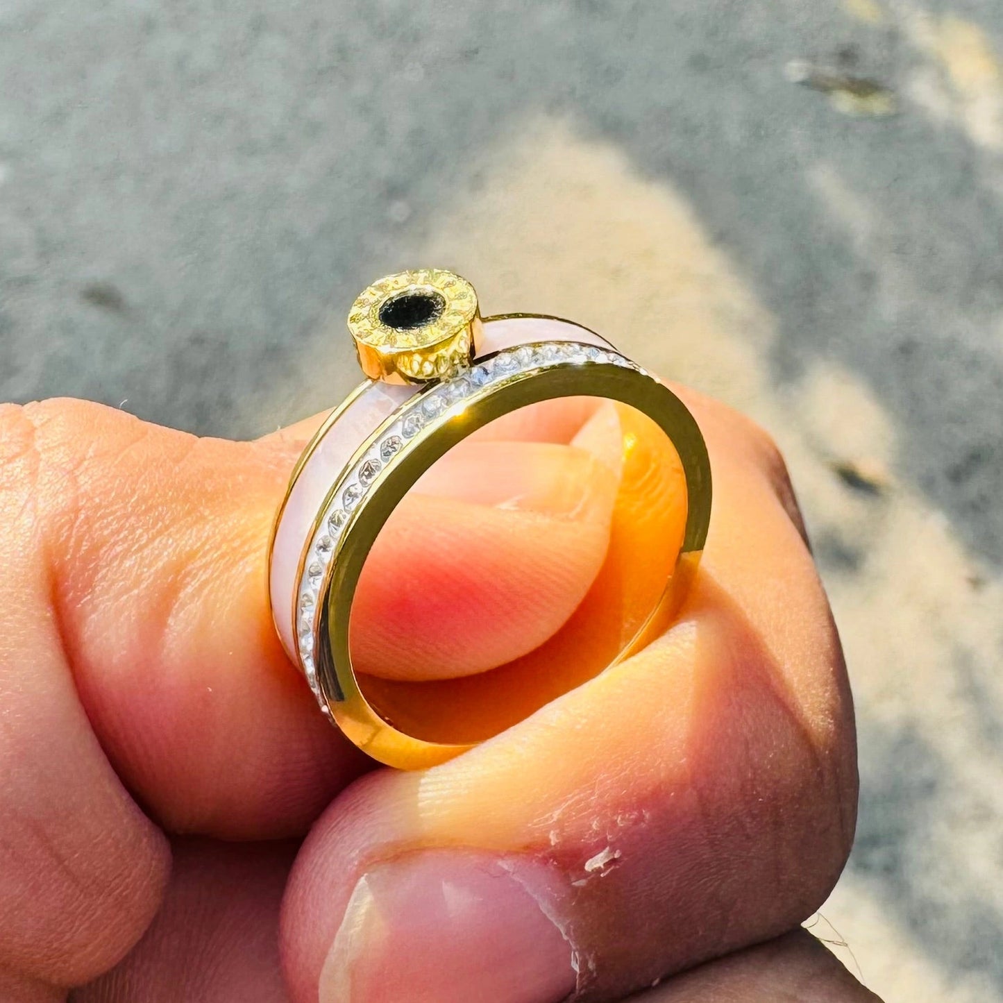 Gold and silver ring on a finger with a blurred background