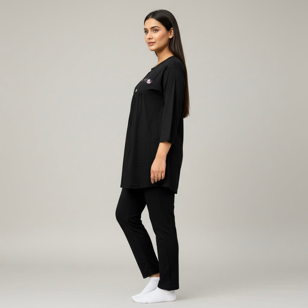 Woman wearing a black outfit with a logo on a gray background