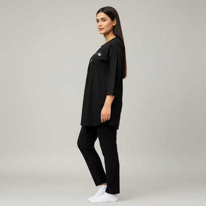 Woman wearing a black outfit with a logo on a gray background