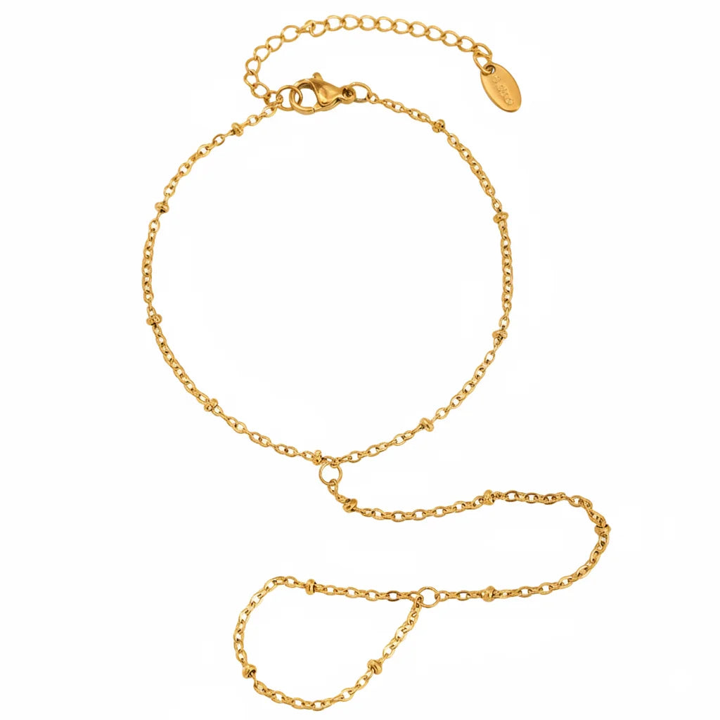 Gold bracelet on a hand with a blurred green background