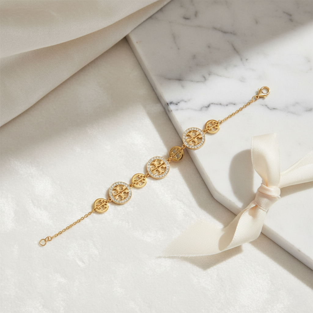 Gold bracelet with circular designs on a marble surface