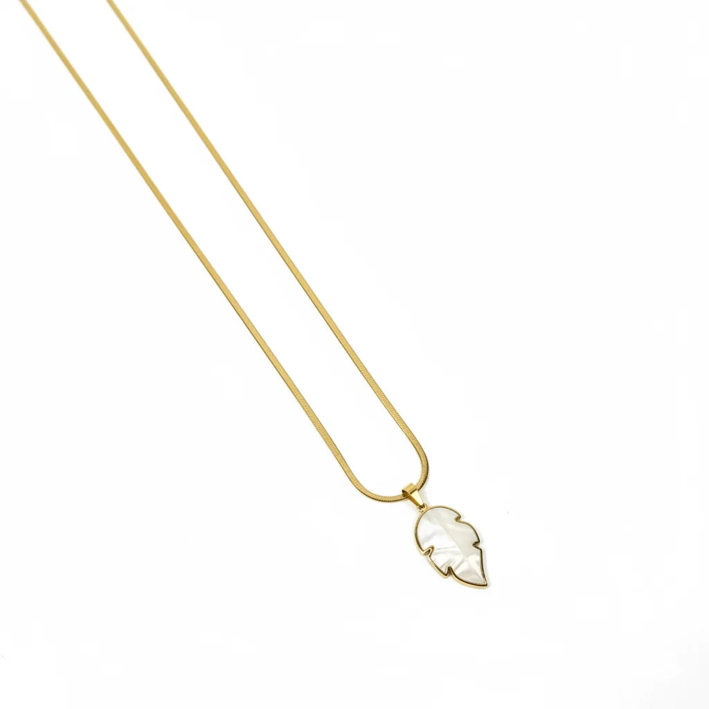 Gold necklace with a leaf-shaped pendant on a white background