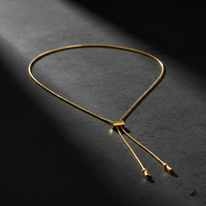 Gold necklace on a dark textured surface