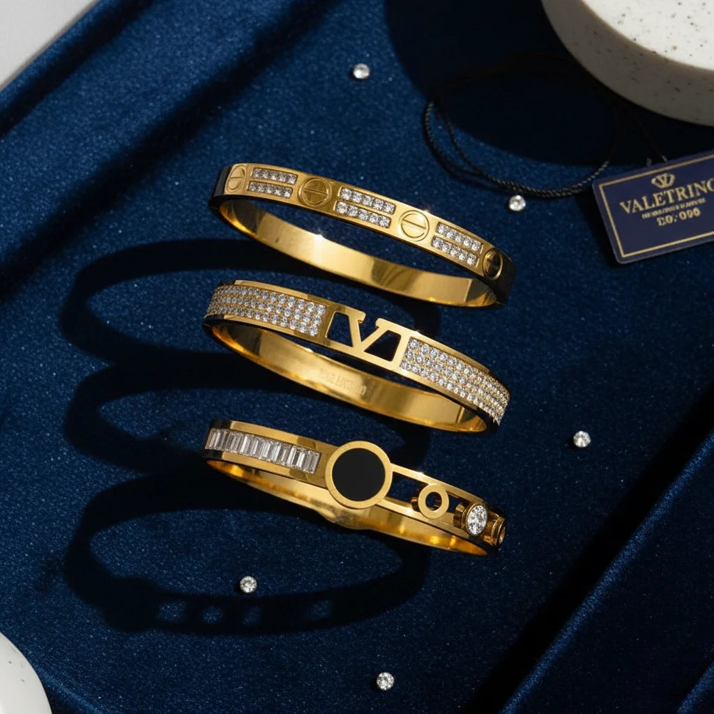 Gold bracelets with diamond accents on a blue velvet surface, with a brand tag visible.
