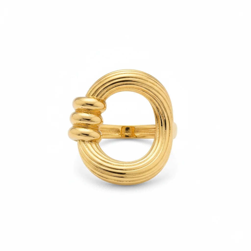 Gold ring with a textured design on a white background