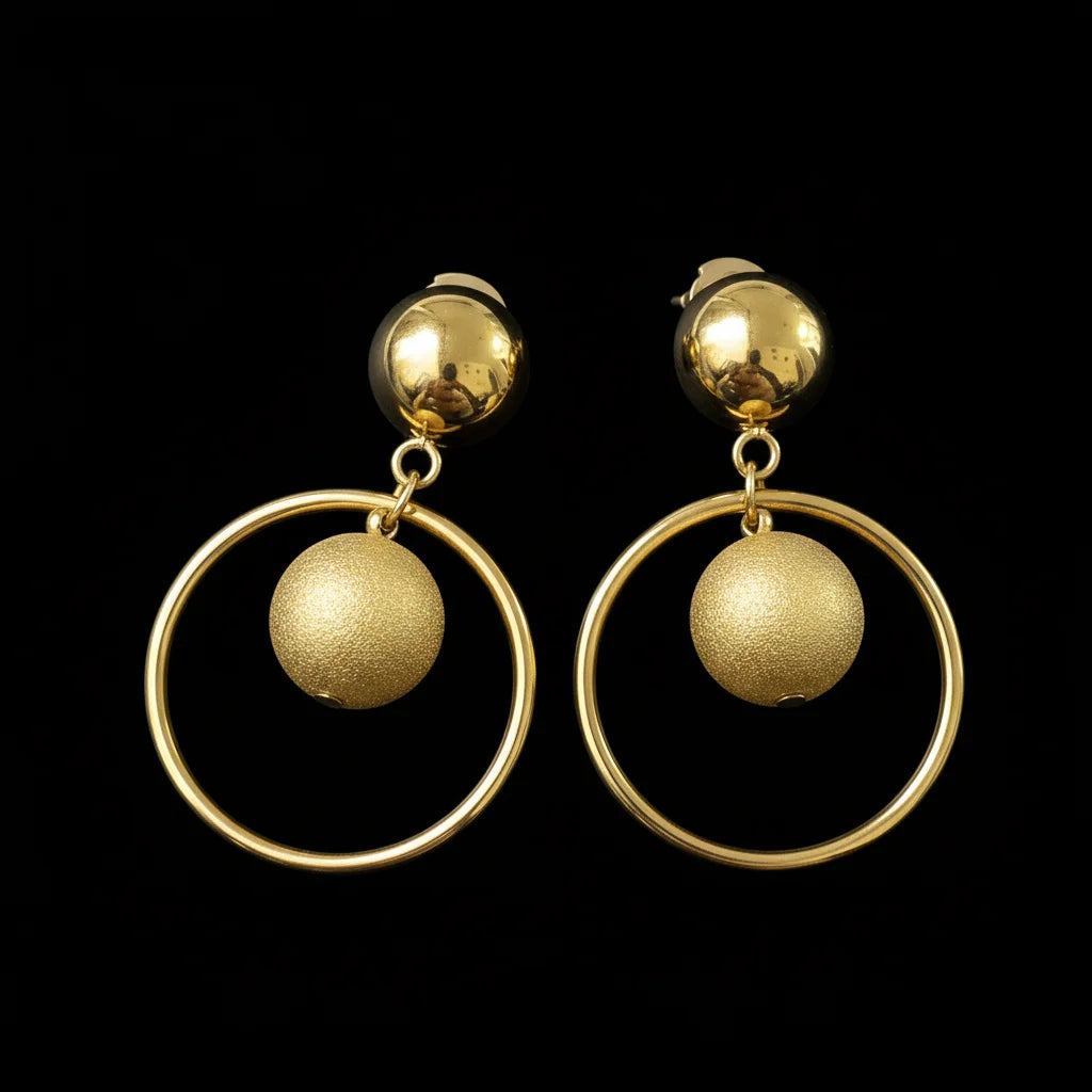Pair of gold earrings with circular designs on a black background
