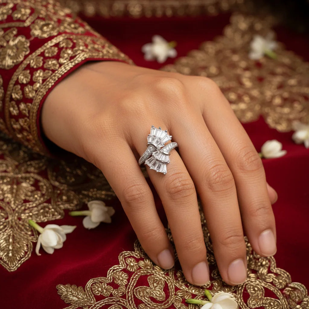 Close-up of a hand wearing a diamond ring with a red and gold embroidered fabric background.