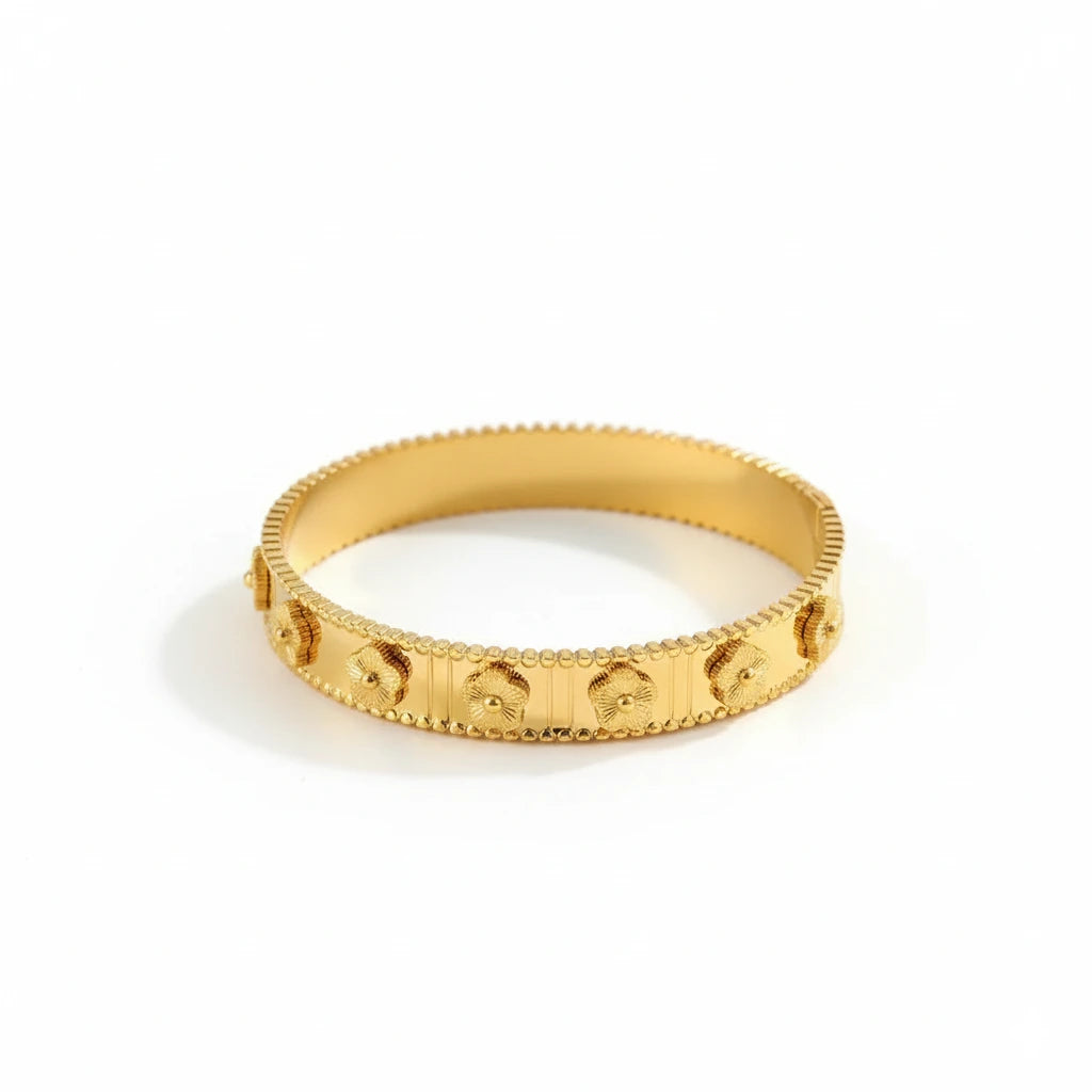 Gold bracelet with intricate design on a white background