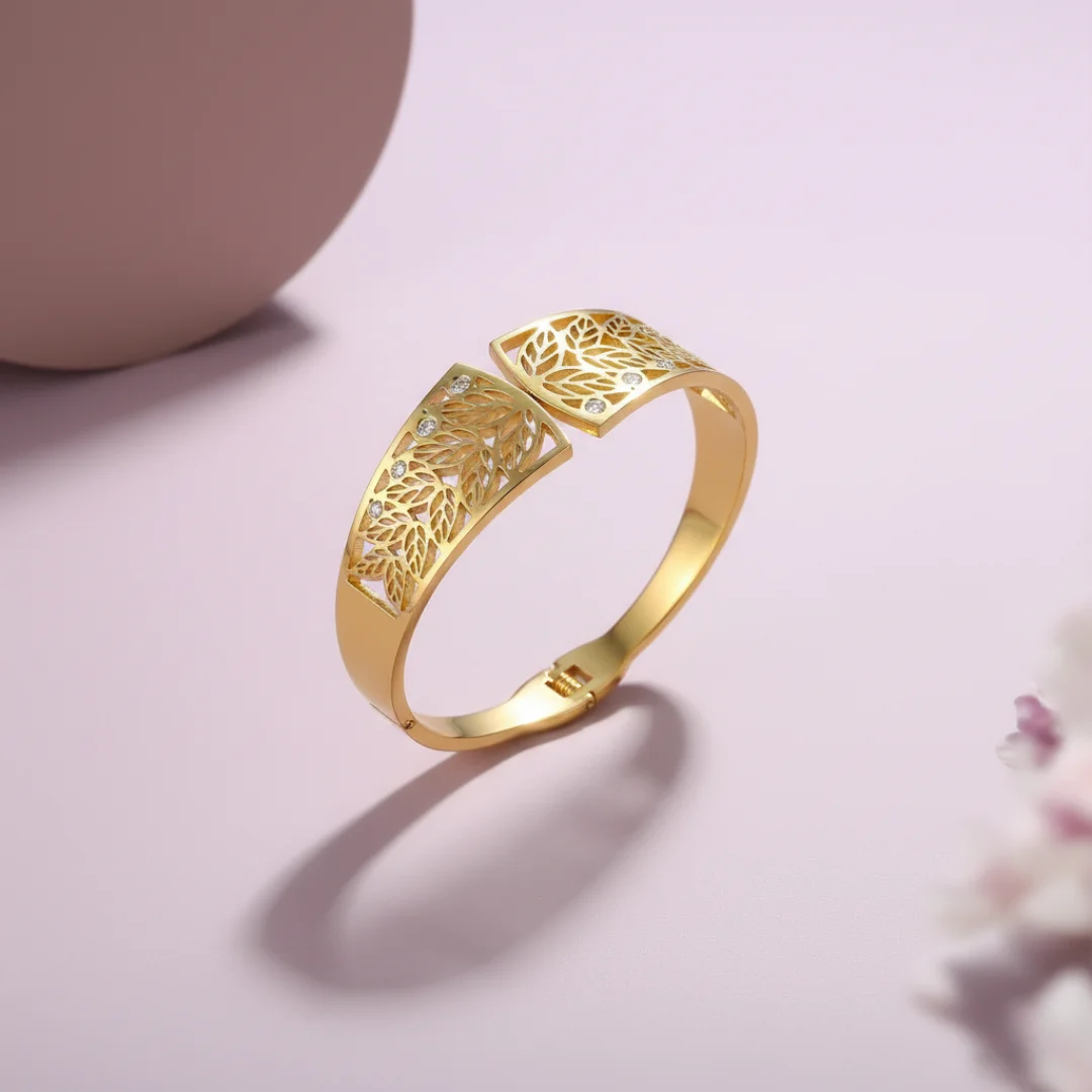 Gold bracelet with intricate design on a light pink background