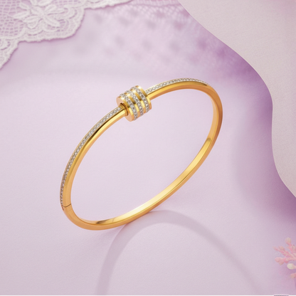 Gold bracelet on a soft pink fabric background
