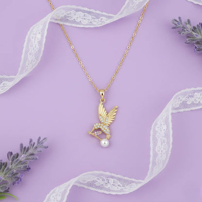 Gold necklace with a pendant featuring a pearl on a purple background with lace and lavender.