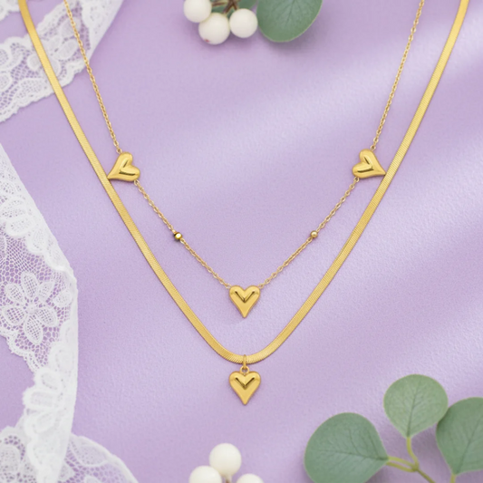 Gold heart-shaped necklace on a purple background with lace and berries