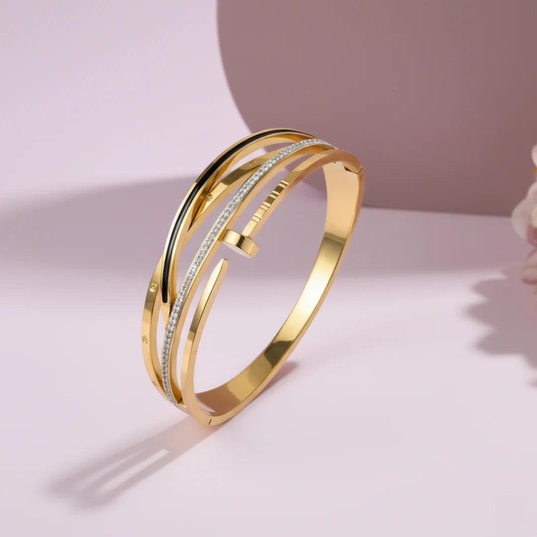 Gold bracelet with multiple bands on a light pink background