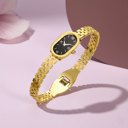 Gold bracelet watch with black dial on a light pink background