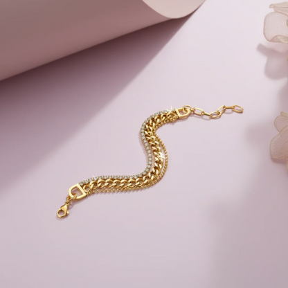 Gold chain bracelet on a light pink background