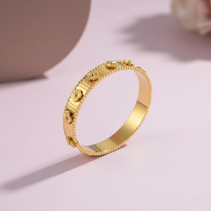 Gold bracelet on a light pink background